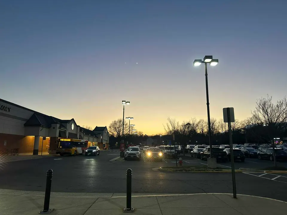 The Hunters Woods Village Center’s parking lot in Reston at dusk (staff photo by Angela Woolsey)