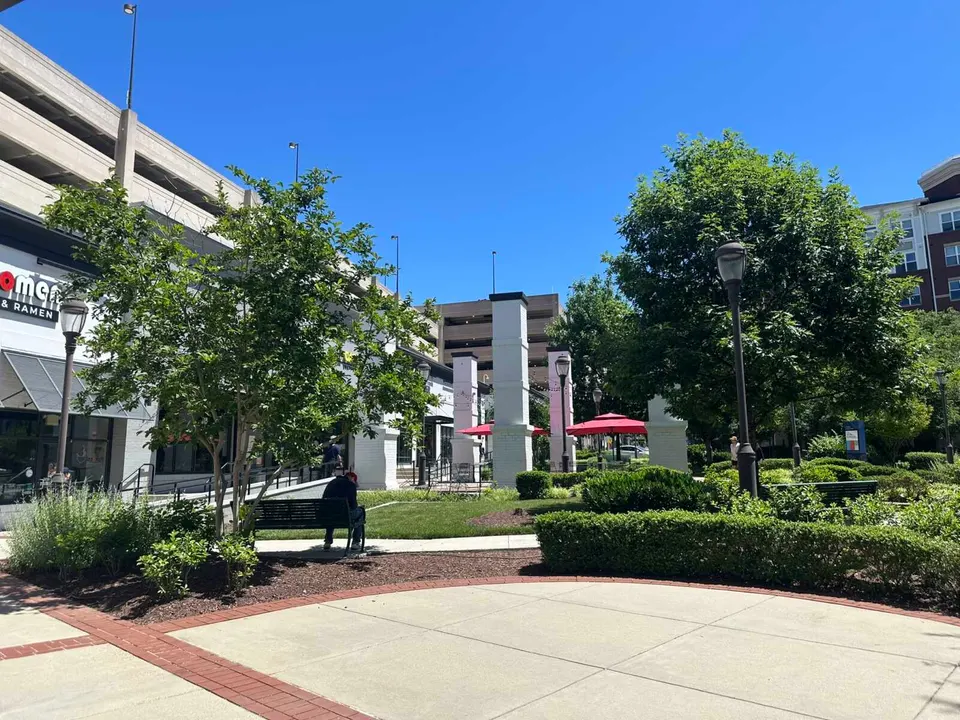 A man sitting on a bench in shade outside Japomen at the Shops at Avenir Place in Merrifield (staff photo by Angela Woolsey)