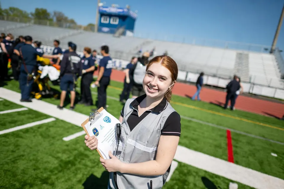Student participates in an emergency response training exercise on a school athletic field.